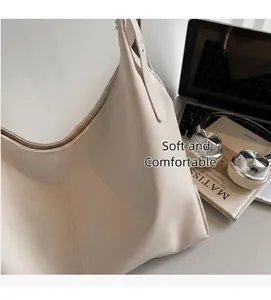 Detail of a large cream-white tote bag next to a laptop and headset for office use