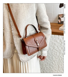 Vue détaillée de la texture tressée marron avec boucle dorée et cuir PU élégant