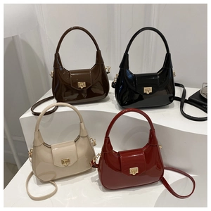 Detail of four patent leather crescent bags in coffee, black, beige, and burgundy colors