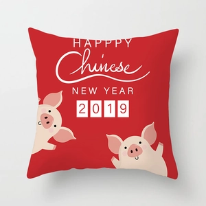 Detail of red festive cushion cover with cartoon pig illustration and New Year text