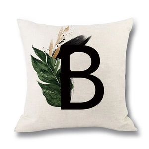 Linen decorative pillow cover featuring a black letter B and tropical green leaves
