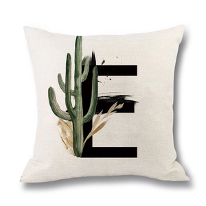 Linen decorative pillow cover featuring a black letter E with cactus and gold leaf patterns