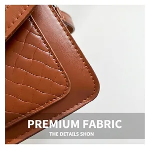Détail macro du sac en cuir marron caramel avec motif matelassé et coutures de précision