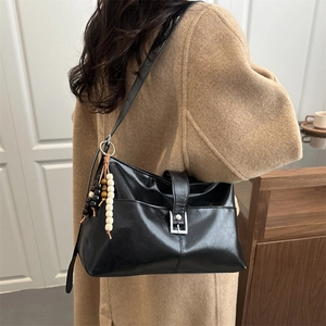 Glossy black PU leather tote bag with vintage metal buckle and wooden bead charm for women