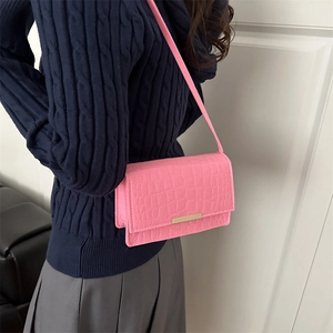Borsa a spalla rosa in pelle a motivo coccodrillo con chiusura oro su modella