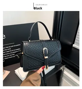 Détail d'un petit sac carré tressé noir avec une boucle métallique dorée