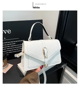 Détail du sac à main blanc motif crocodile avec boucle élégante en métal doré en forme de U