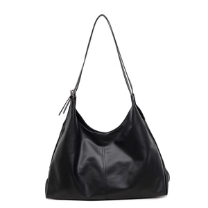 Minimalist black leather tote bag with vertical stitching and slim straps on white background