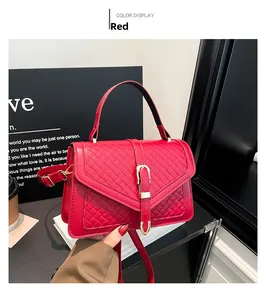 Détail d'un sac à main rouge tissé avec boucle dorée en U et bandoulière réglable