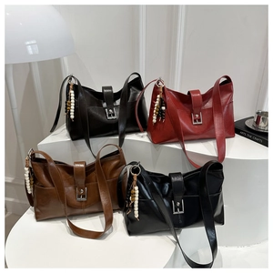 Vista dettagliata di quattro borse tote in pelle vintage nei toni marrone, rosso e nero