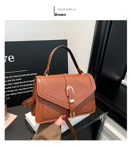 Détail du sac à main marron à motif tressé avec boucle en fer à cheval dorée