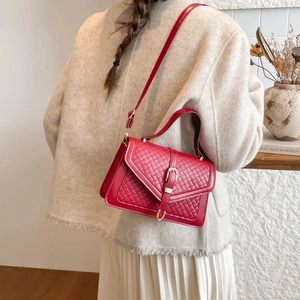 Sac à bandoulière rouge avec texture tissée et boucle dorée, porté pour les dimensions