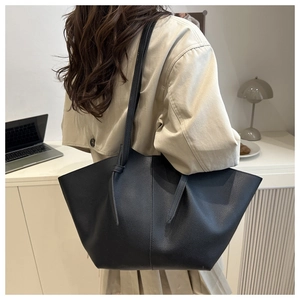 Détail du grand sac cabas noir en cuir grainé avec bandoulière à nœud élégante