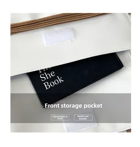 Close-up of white canvas shoulder bag front storage pocket with Velcro closure detail