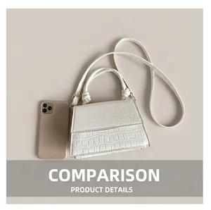 Detail of white crocodile embossed leather handbag with elegant knot handle and strap