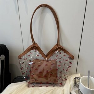 Detail view of transparent PVC cherry print tote bag with brown leather interior pouch