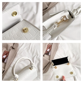Detail of white crocodile embossed tote with gold magnetic buckle and knot handle