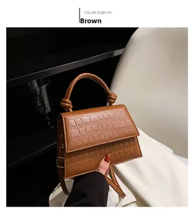 Detail view of the brown crocodile pattern leather handbag with unique knotted handle design