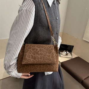 Sac à bandoulière léopard marron avec chaîne dorée porté par un mannequin de mode