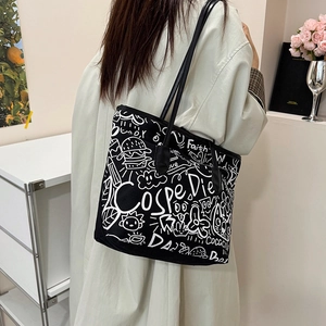 Minimalist black graffiti canvas tote bag with artistic white prints and leather straps