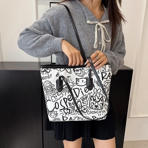 Chic white tote bag with black graffiti prints and adjustable shoulder strap for women