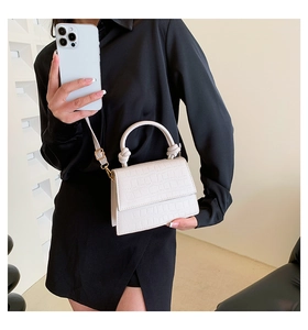 Detail shot of white faux leather small handbag with elegant crocodile embossing pattern