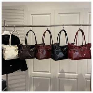 Detailed view of high-gloss leather bucket bags in five colors with belt buckle straps