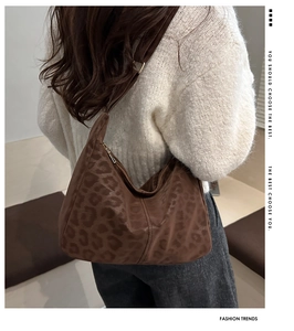 Detail of trendy leopard print hobo bag with wide strap and soft texture finish