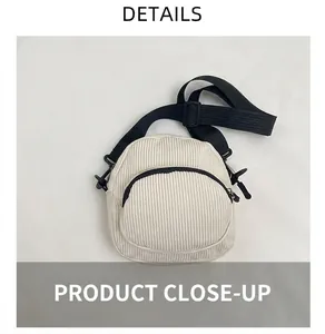 Detailed view of ivory corduroy mini crossbody bag with zipper pockets and adjustable strap