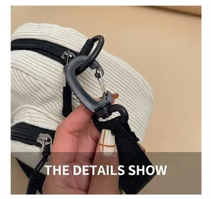 Detail showing high-quality black plastic carabiner hook on corduroy shoulder bag strap