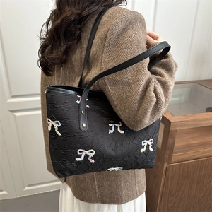 Quilted black tote bag with colorful sequin bows and letter jacquard detail