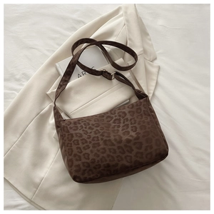 Detail of leopard print hobo bag with adjustable wide strap on white blazer backdrop