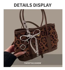 Detail of leopard print handbag with white lace bow and brown leather strap handle