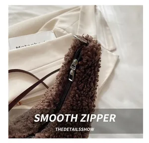 Close-up of smooth metal zipper and brown plush faux fur texture on fashion handbag