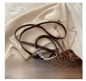 Dettaglio borsa leopardata con tracolle marroni e fiocco in pizzo bianco decorativo