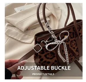 Detail of leopard print plush bag with leather strap and white lace bow decoration
