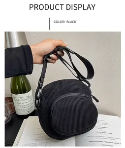 Detail of black corduroy shell crossbody bag with front zipper and adjustable strap