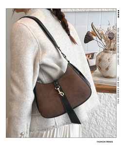 Detail of vintage brown suede hobo bag with contrast leather trim and golden clasp buckle
