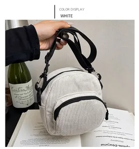 Detail of white corduroy mini crossbody bag with front zipper pocket and adjustable strap