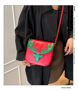 Détail du sac bandoulière de Noël rouge avec motif renne vert et finition en cuir festif