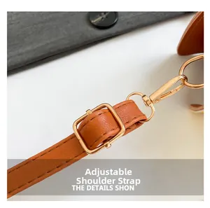 Detail of adjustable brown PU leather shoulder strap with golden metal buckle and lobster clasp