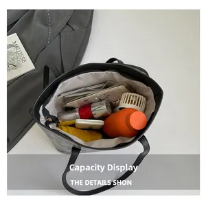 Vue de dessus du grand sac cabas noir montrant l'intérieur spacieux et les objets quotidiens