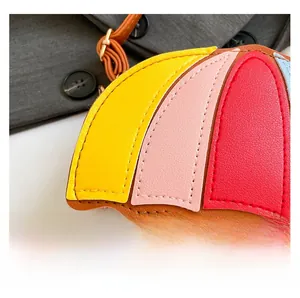 Detail shot of multi-color umbrella shaped leather bag showing fine stitching and metal buckles