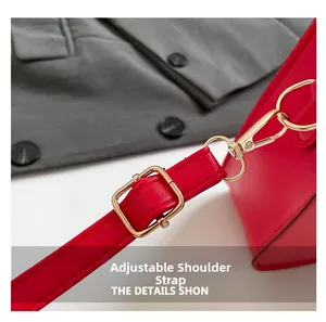 Détail de la bandoulière réglable en cuir PU rouge avec boucles en métal doré poli