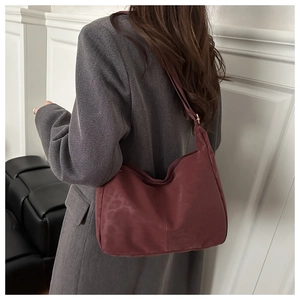 Detail of burgundy leopard print shoulder bag in suede finish with adjustable strap