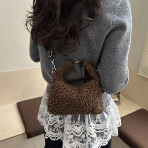 Borsa a mano marrone in pile con tracolla indossata da una modella in un ambiente invernale