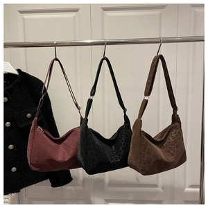 Three large leopard print hobo bags in red, black and brown colors on display