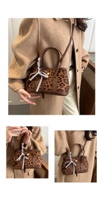 Détail d'un sac léopard avec poignées en cuir marron et ruban de dentelle décoratif