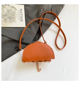 Detailed close-up of an orange umbrella-shaped crossbody bag on a gray blazer background
