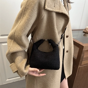 Mini borsa a tracolla in shearling nero con manico tondo in metallo su modella